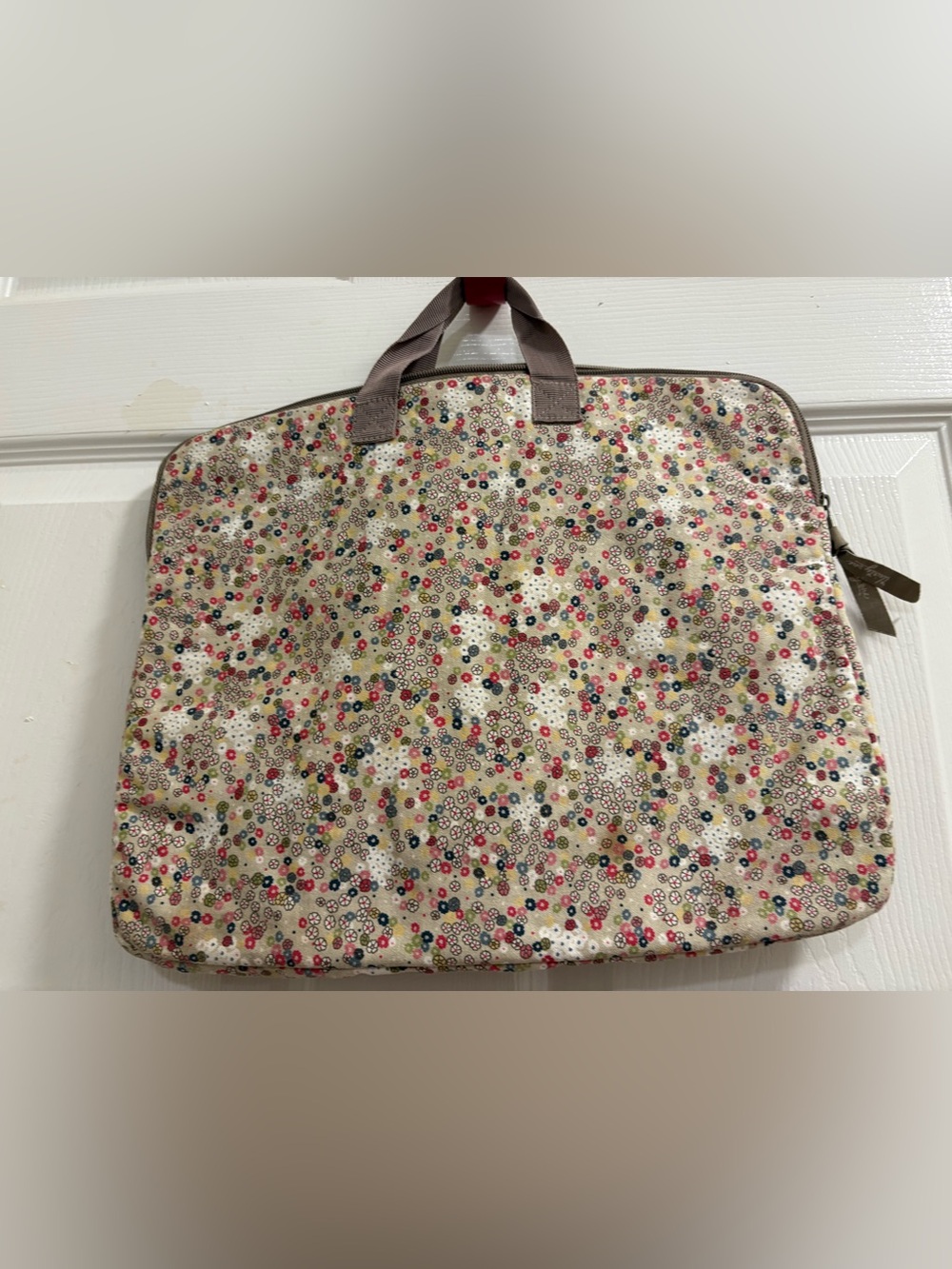 Thirty-One floral laptop sleeve features a floral pattern on a cream background